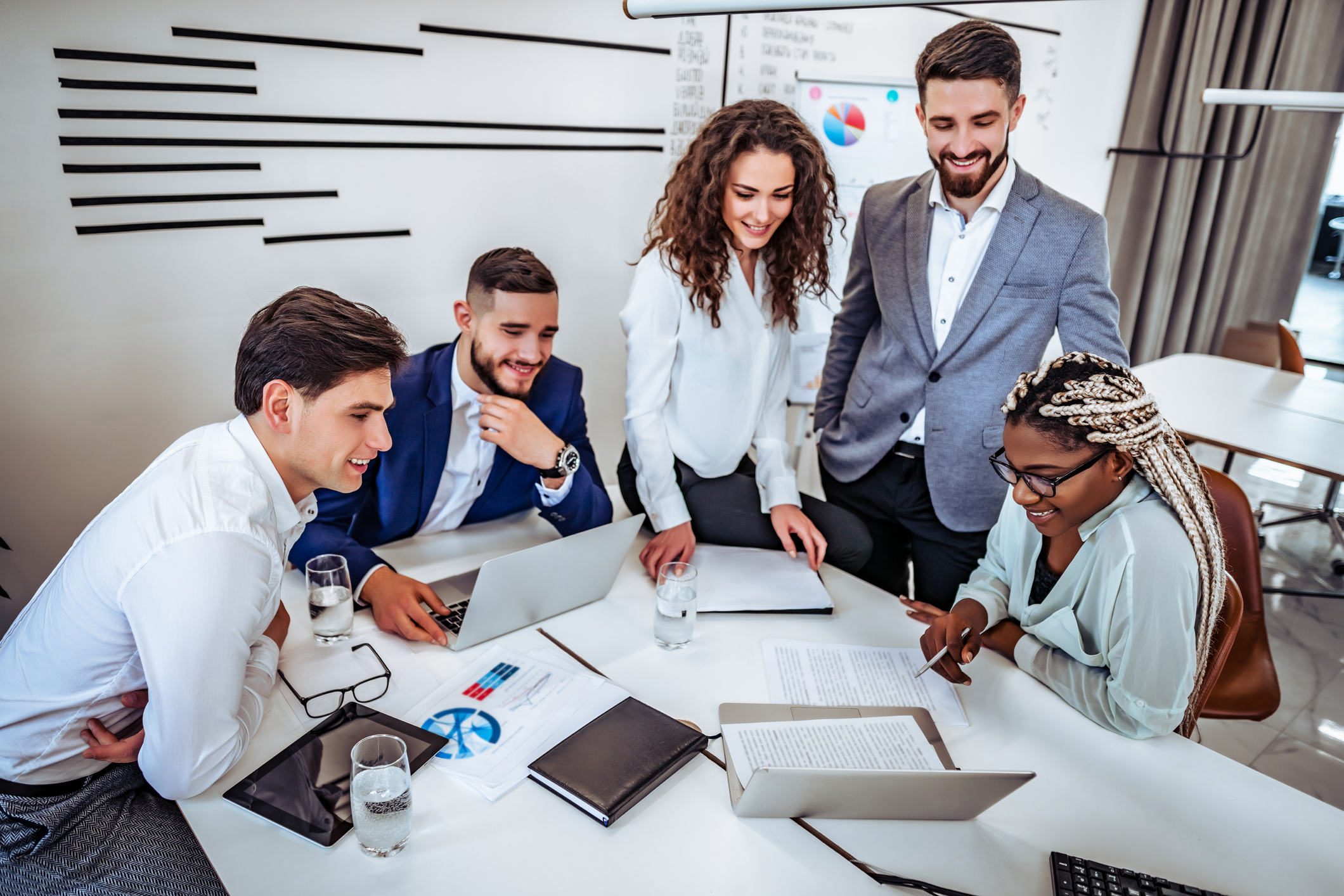 A group of young business people are communicating a project together in an office. Business concept. A group of young business people are communicating a project together in an office. Business concept.